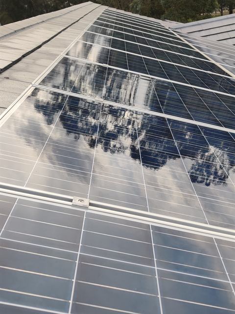 Close view of clean panel glass reflecting cloud